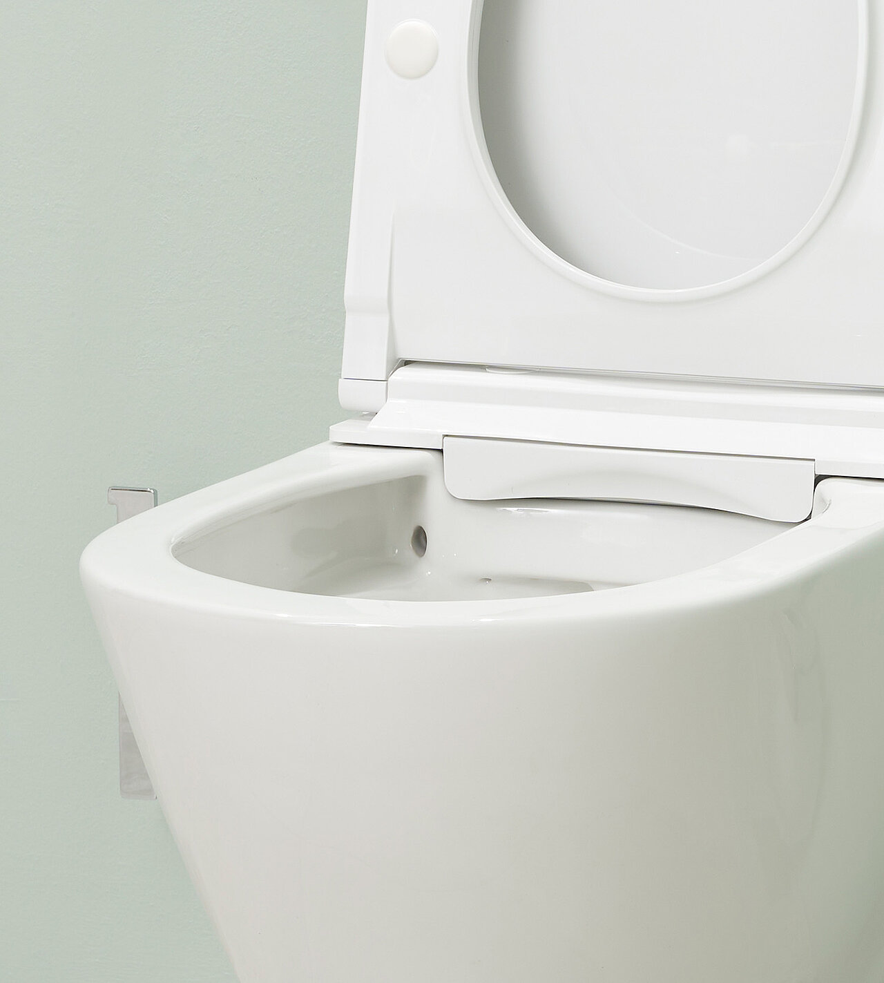 Nahaufnahme eines modernen Dusch-WCs mit geöffnetem Deckel vor einer hellgrünen Wand