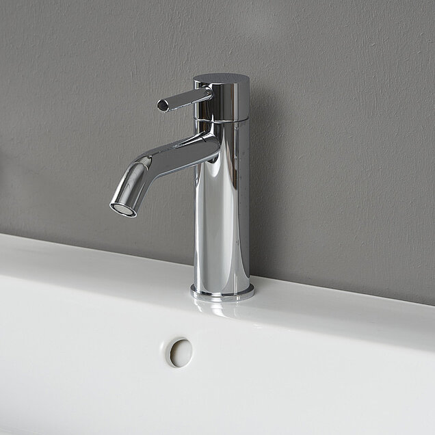 Eine moderne Chrom-Armatur mit einem Einhebelgriff ist auf einem weißen Waschbecken 