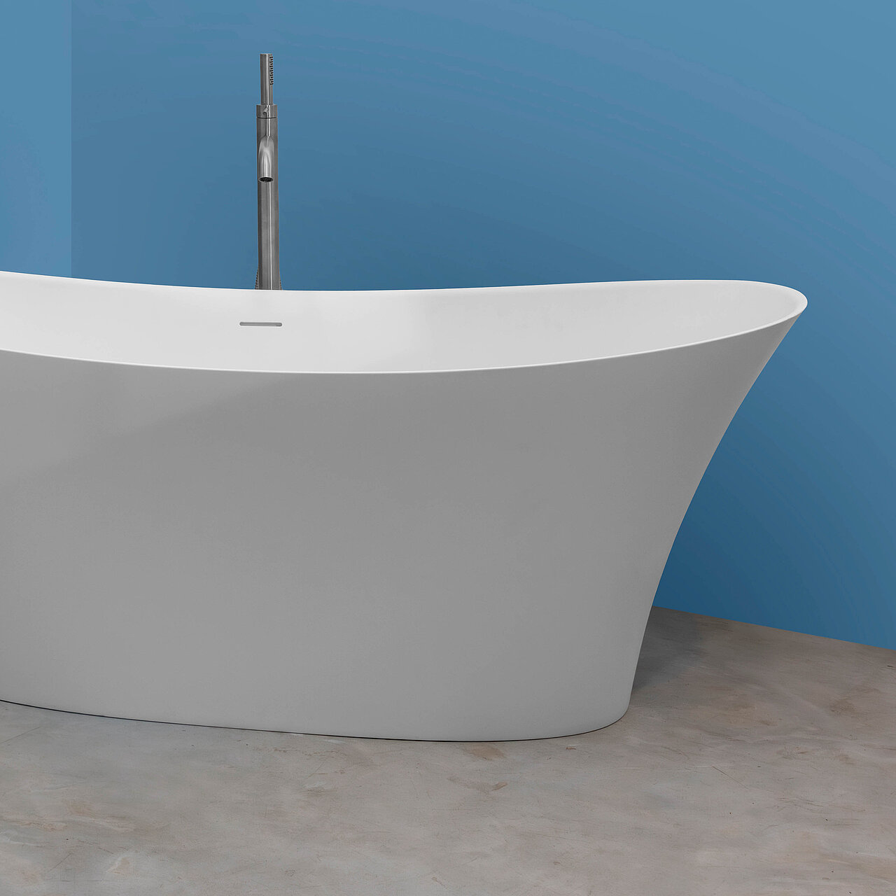 Ein blau gestrichenes Badezimmer mit einer freistehenden Badewanne aus dem samtweichen SolidSurfce-Material und einem Bidet sowie WC jeweils mit einer matten chromfarbenen Armatur und einem wunderschönen Bild aus Italien, dass an der Wand hängt