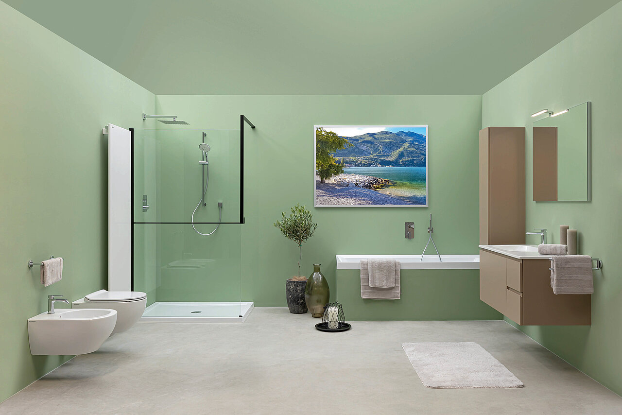 Badezimmer mit grünen Wänden, einem schwebenden beigen Waschtisch, einer freistehenden Badewanne, einem Wandspiegel.