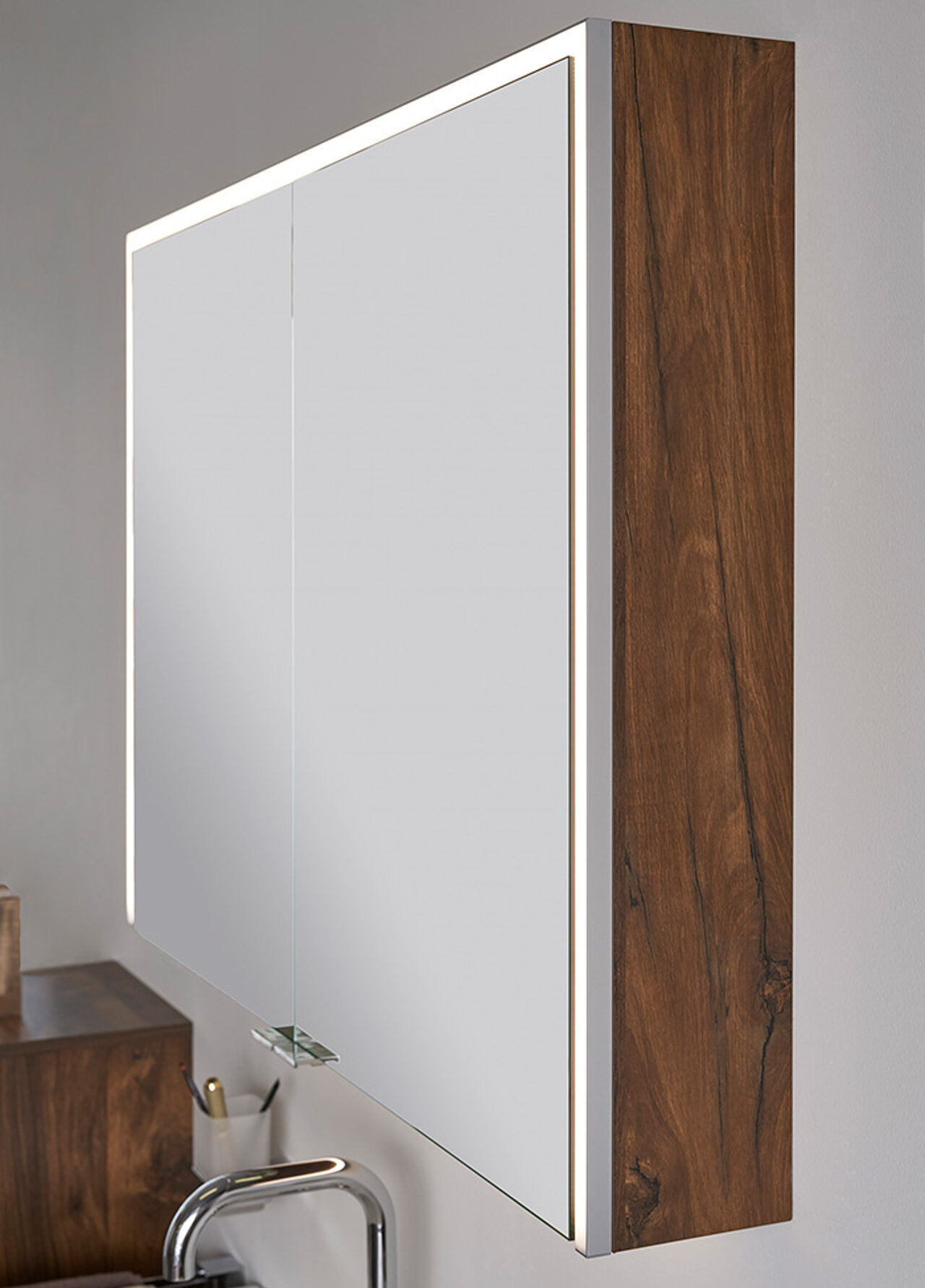 Ein wandmontierter Badezimmer-Spiegelschrank mit einem Holzrahmen und integrierter LED-Beleuchtung