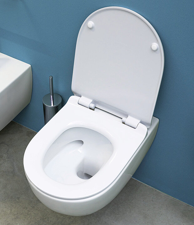 Weiße Toilette mit geöffnetem Deckel, die an einer blauen Wand montiert ist.