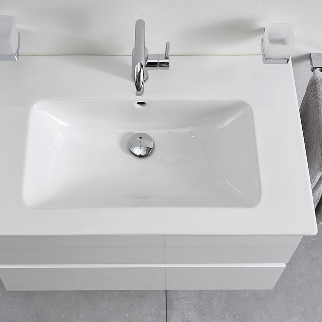 Ein modernes weißes, rechteckiges Waschbecken mit einem verchromten Wasserhahn