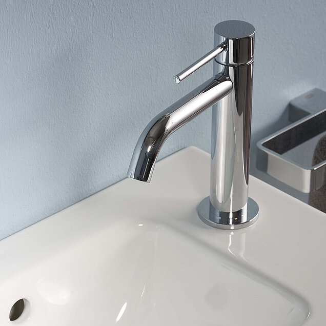 Eine Chromarmatur mit Einhebelgriff ist auf einem weißen Waschbecken installiert.