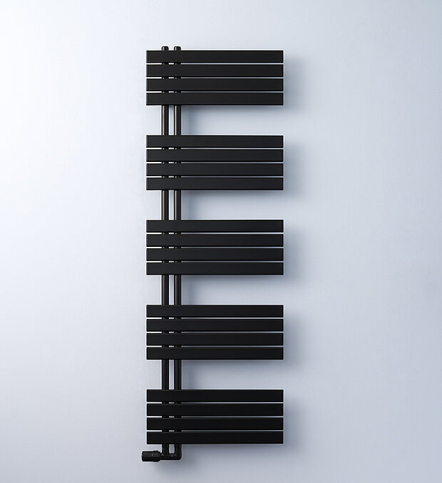 Ein moderner, schwarzer Badheizkörper vor einer schlichten, hellen Wand. 