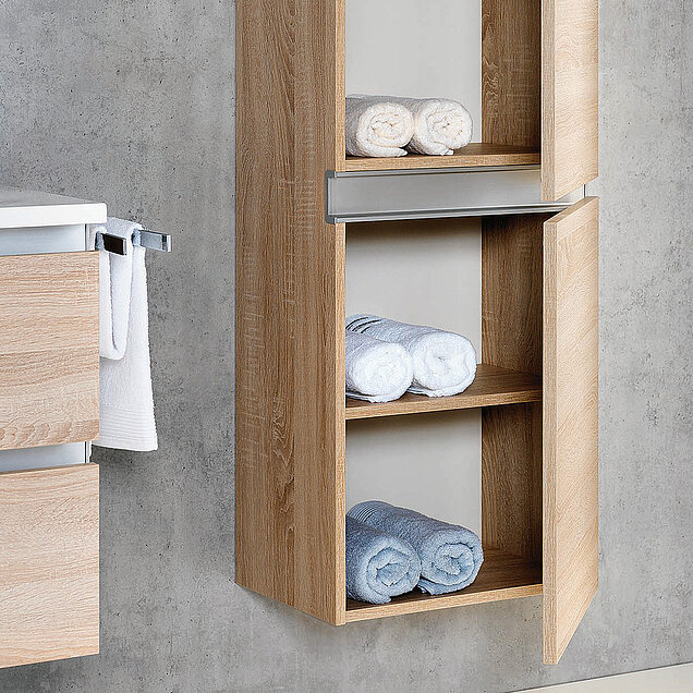 Hölzerner Badezimmerschrank, an einer Wand montiert, mit Regalen, in denen aufgerollte weiße und blaue Handtücher liegen.