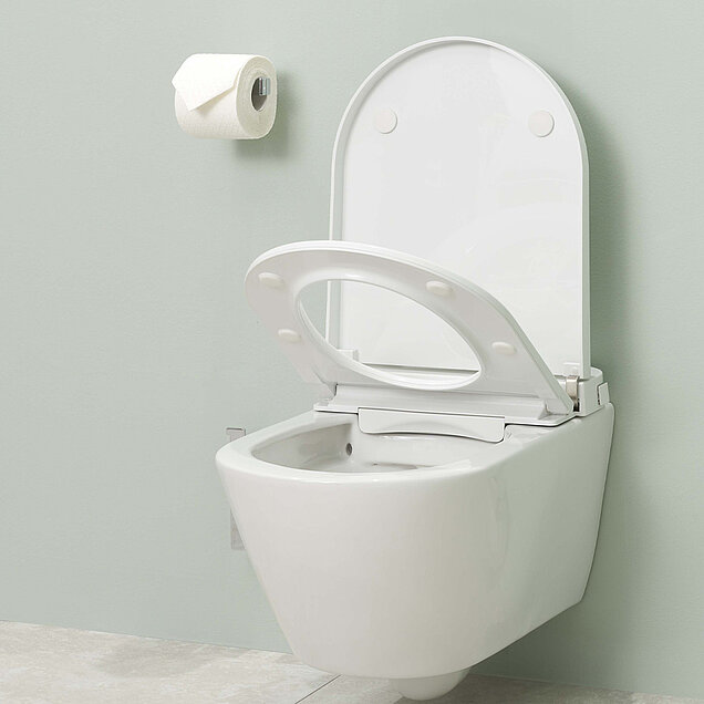 Eine modernes weißes Dusch-WC mit hochgeklapptem Sitz und Deckel.