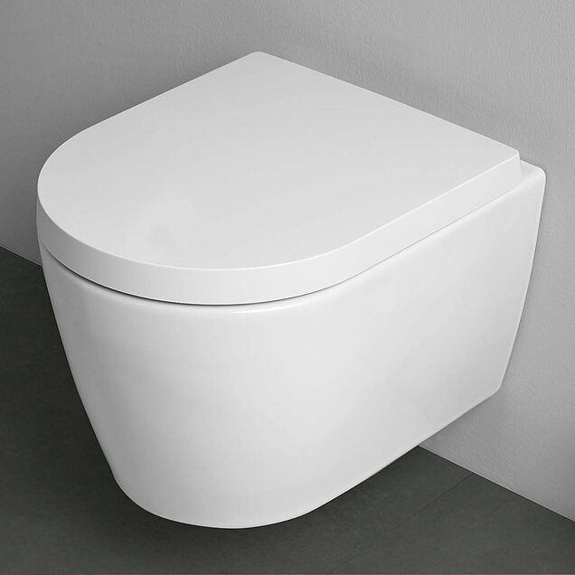 Eine moderne, weiße, wandmontierte Toilette mit geschlossenem Deckel.